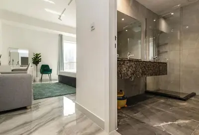 a bathroom with a sink and a living room at AHLAN Dubai Marina JBR in Dubai