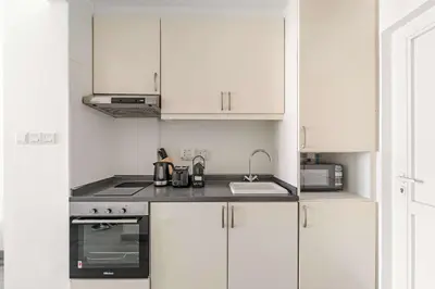 a white kitchen with white cabinets and a sink at Silkhaus Sea View Studio in Palm Jumeirah in Dubai