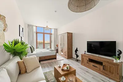a living room with a couch and a flat screen tv at Silkhaus Beach Access Studio in Palm Views East in Dubai
