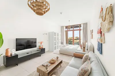 a living room with a couch and a tv at Silkhaus Offshore Studio in Palm Views East Tower in Dubai