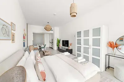 a white living room with a large white couch at Silkhaus Offshore Studio in Palm Views East Tower in Dubai