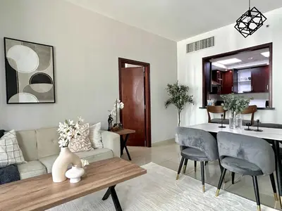 a living room with a couch and a dining room at Silkhaus 1BR Downtown Heart in Emaar Tower in Dubai