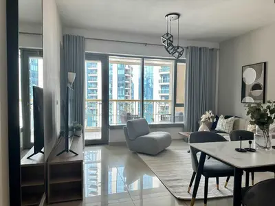 a living room with a couch and a table with chairs at Silkhaus 1BR Downtown Heart in Emaar Tower in Dubai