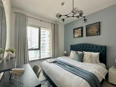 a bedroom with a blue bed and a window at Silkhaus 1BR Downtown Heart in Emaar Tower in Dubai