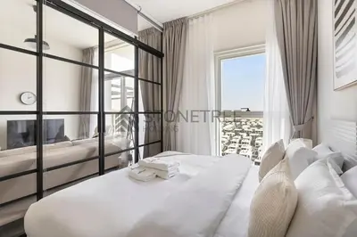 a bedroom with a large white bed and a window at Modern 1BR at Collective Tower 1 Near Hills Mall in Dubai