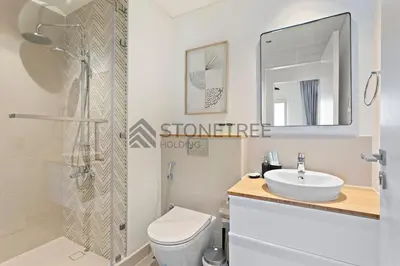 a bathroom with a toilet and a sink and a shower at Modern 1BR at Collective Tower 1 Near Hills Mall in Dubai