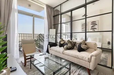 a living room with a couch and a glass table at Modern 1BR at Collective Tower 1 Near Hills Mall in Dubai