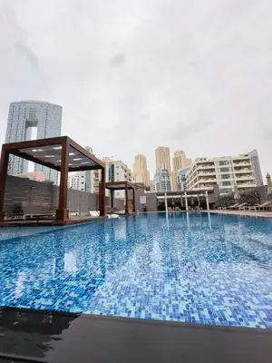 a large swimming pool with a city skyline in the background at Chic Marina Vibes 1BR Pad with Epic Views in Dubai