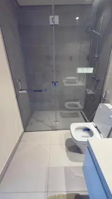 a bathroom with a toilet and a glass shower at Chic Marina Vibes 1BR Pad with Epic Views in Dubai