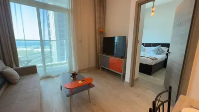 a living room with a couch and a television and a bed at Chic Marina Vibes 1BR Pad with Epic Views in Dubai