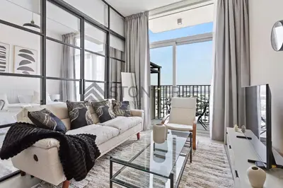 a living room with a couch and a glass table at Cozy 1BR at Collective Tower 1 Near Hills Mall in Dubai