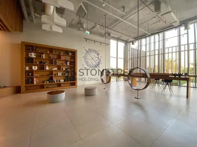 a large room with a table and a sign on the wall at Cozy 1BR at Collective Tower 1 Near Hills Mall in Dubai
