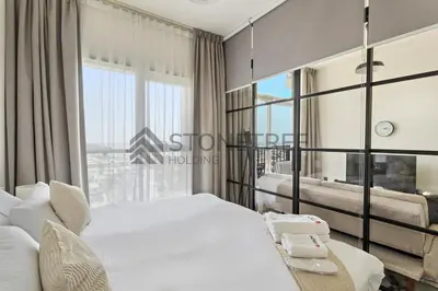 a bedroom with two beds and a large window at Cozy 1BR at Collective Tower 1 Near Hills Mall in Dubai