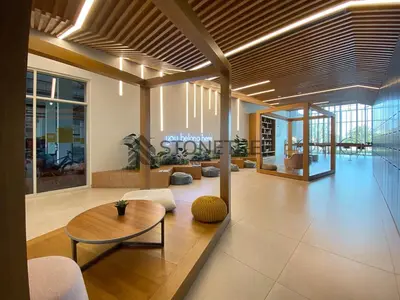 a lobby with a table and chairs in a building at Cozy 1BR at Collective Tower 1 Near Hills Mall in Dubai