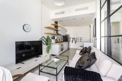 a living room with a white couch and a tv at Bright 1BR at Collective Tower 1 Near Hills Mall in Dubai
