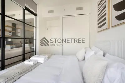 a white bed with white pillows in a bedroom at Bright 1BR at Collective Tower 1 Near Hills Mall in Dubai