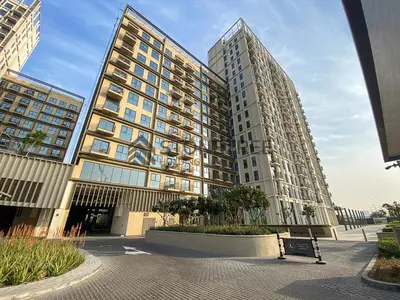 two tall buildings with a bench in front of them at Bright 1BR at Collective Tower 1 Near Hills Mall in Dubai