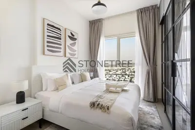 a white bedroom with a large bed and a window at Bright 1BR at Collective Tower 1 Near Hills Mall in Dubai