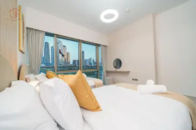a bedroom with a white bed and a large window at Cozy 2-Bed Home with Burj Khalifa Views 204GR-2 in Dubai