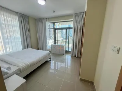 a bedroom with a bed and a large window at Blakely 2BR Lakeview Retreat - Open Balcony and Marina Views in Dubai
