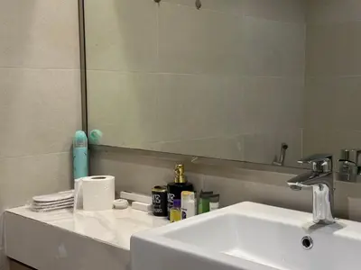 a bathroom with a white sink and a mirror at Sunset Haven Chic Creek Studio in Dubai