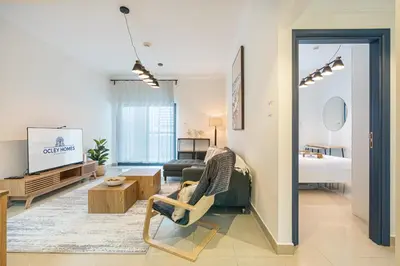 a living room with a couch and a tv at Elegant Home in the Heart of Marina in Dubai