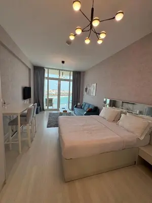 a bedroom with a large bed and a dining room at Deluxe Waterfront Unit in Heart Of Dubai Palm Jumeirah in Dubai