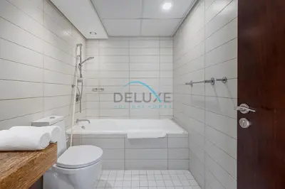 a bathroom with a toilet and a bath tub at Tranquil 1BR in Burj Views Tower B, Downtown by Deluxe Holiday Homes in Dubai