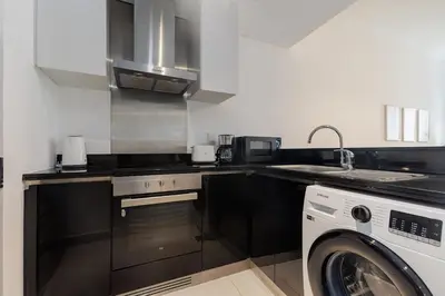 a kitchen with a sink and a washing machine at Sea View, Easy Access, Close to All Amenities in Dubai