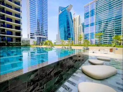a swimming pool in a city with tall buildings at Stylish 1BR in the heart of Dubai - easy walk by the canal in Dubai