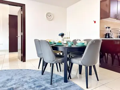 a dining room with a blue table and chairs at Amazing 2 Bedroom in Al Rabia Tower in Majan 6PPL in Dubai