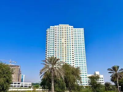a tall building with palm trees in front of it at Amazing 2 Bedroom in Al Rabia Tower in Majan 6PPL in Dubai