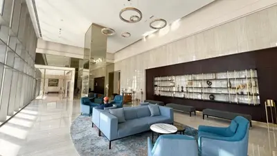 a lobby with blue couches and chairs in a building at Full Burj Khalifa View, TOP Floor, 5min Dubai Mall in Dubai