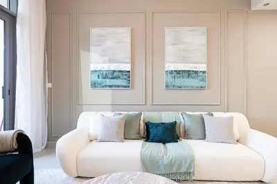 a living room with a white couch with pillows at Full Burj Khalifa View, TOP Floor, 5min Dubai Mall in Dubai