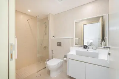 a bathroom with a toilet and a sink and a shower at Beachfront Bliss Luxurious 3-BR Stay in JBR in Dubai