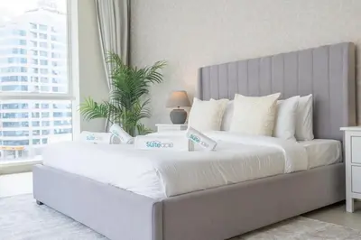 a large bed with white sheets in a bedroom at Beachfront Bliss Luxurious 3-BR Stay in JBR in Dubai