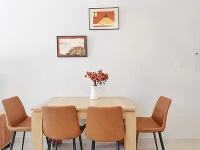 a dining room table with chairs and a vase with flowers at CaiCai Homes AG Tower-Business Bay in Dubai