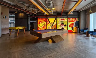 a ping pong table in a room with a pool table at Elegant 2BR Living Steps from Dubai Hills Park in Dubai