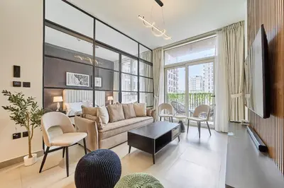 a living room with a couch and a table at Elegant 2BR Living Steps from Dubai Hills Park in Dubai
