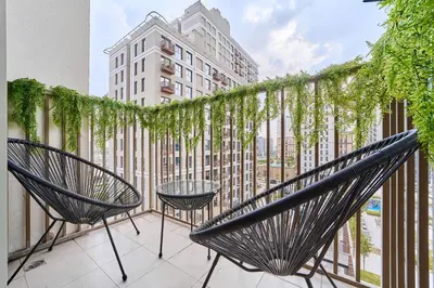 a balcony with two chairs and a table at Elegant 2BR Living Steps from Dubai Hills Park in Dubai