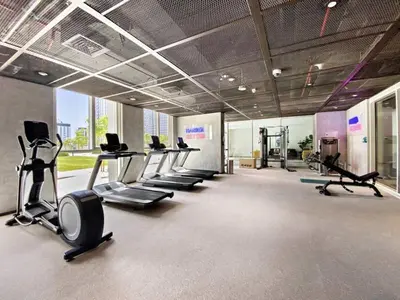 a gym with a row of treadms and cardio machines at Elegant & Bright 1BR Getaway Near Dubai Hills Park in Dubai