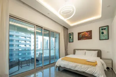 a bedroom with a bed and a large window at Dubai Marina - 1BHK Homely Apartment in Dubai