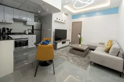 a kitchen and living room with a couch and a table at Dubai Marina - 1BHK Homely Apartment in Dubai