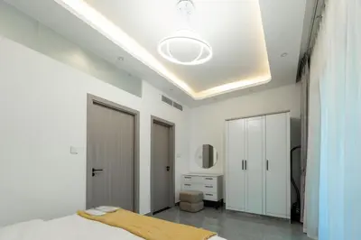 a white bedroom with a bed and a ceiling at Dubai Marina - 1BHK Homely Apartment in Dubai