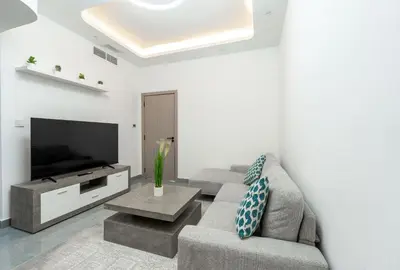 a living room with a couch and a flat screen tv at Dubai Marina - 1 BHK Elegant Apartment in Dubai