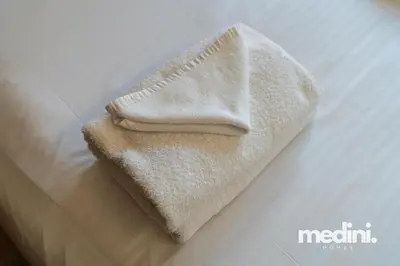 a pile of towels sitting on top of a bed at 10 min from Burj Khalifa - Sauna - Gym - Damac Reva in Dubai