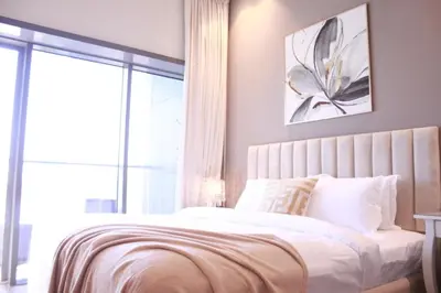 a bedroom with a bed with white sheets and a window at Spacious Spectacular Skyline View in Heart of Dubai in Dubai