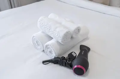 a hair dryer and towels on a table with a microphone at StayShort - Bright and Airy 1-Bedroom Apartment Perfect for 4 in Dubai Marina in Dubai