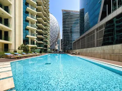 a swimming pool in a city with tall buildings at 2BR apartment in Missoni in Dubai