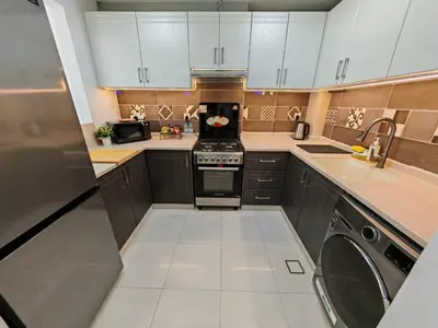 a small kitchen with a stove and a dishwasher at Silicon Heights II in Dubai